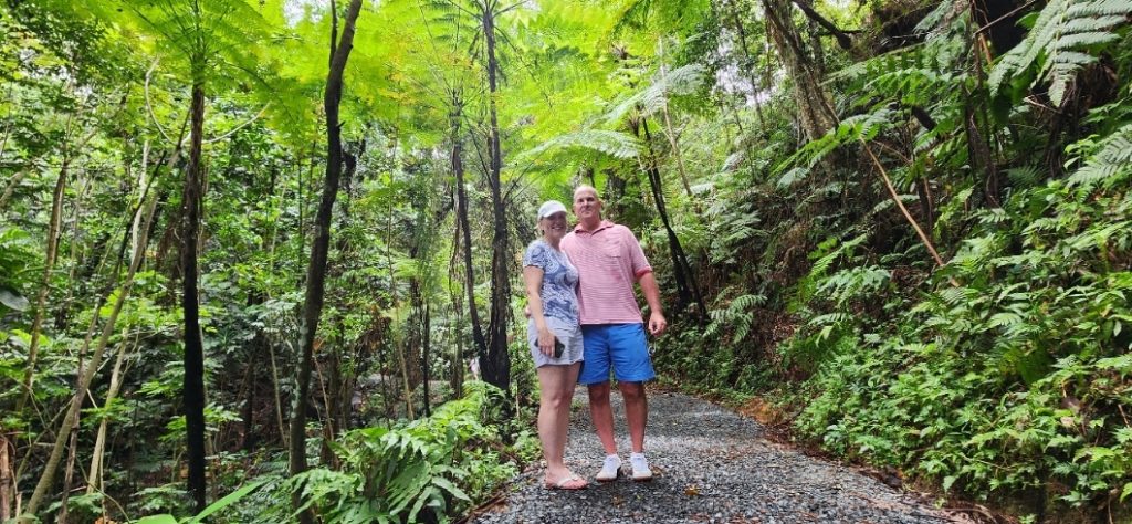 A senior couple takes a peaceful and safe walk along the lush Angelito Trail in El Yunque Rainforest, surrounded by vibrant greenery and serene natural beauty. This safe and enjoyable outing is part of Bucketlist Tours’ Colonial Wonders and Serene Rainforest: Old San Juan and El Yunque private experience, designed for comfort and discovery.