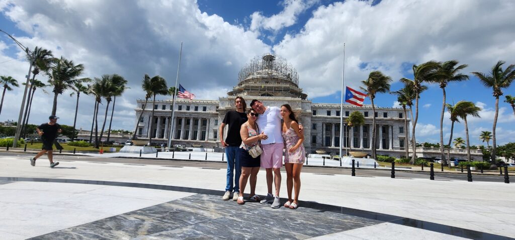 Family traveling to Puerto Rico experiencing Bucketlist Tours’ Old San Juan Ageless Elegance, Heritage, and Spirits private tour, exploring Puerto Rico's rich history and cultural evolution from Spanish to American influences, captured in front of the iconic State Capitol building.