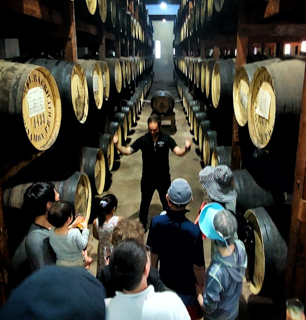 Family traveling to Puerto Rico with seniors and kids experiencing Bucketlist Tours' Old San Juan Ageless Elegance, Heritage, and Spirits private tour, doing the backstage historic tour at World's Finest Rum Distillery: Ron del Barrilito.