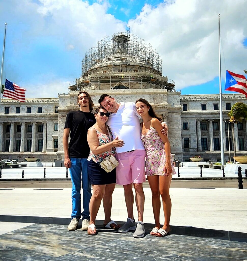 Family traveling to Puerto Rico experiencing Bucketlist Tours’ Old San Juan Ageless Elegance, Heritage, and Spirits private tour, exploring Puerto Rico's rich history and cultural evolution from Spanish to American influences, captured in front of the iconic State Capitol building.