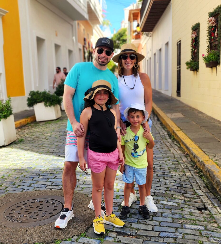 Young Family with children traveling to Puerto Rico experiencing Bucketlist Tours’ Old San Juan Ageless Elegance, Heritage, and Spirits private tour, walking along the narrow cobblestone streets of Old San Juan, discovering its tales and secrets amidst vibrant colonial architecture.