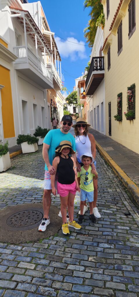 Young Family with children traveling to Puerto Rico experiencing Bucketlist Tours’ Old San Juan Ageless Elegance, Heritage, and Spirits private tour, walking along the narrow cobblestone streets of Old San Juan, discovering its tales and secrets amidst vibrant colonial architecture.