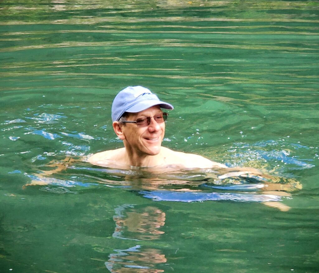 A smiling customer from a couple enjoying the cool and refreshing waters of the pond at the end of Angelito Trail in El Yunque Rainforest. This peaceful and rejuvenating experience is included in Bucketlist Tours’ Colonial Wonders and Serene Rainforest private Old San Juan tour.