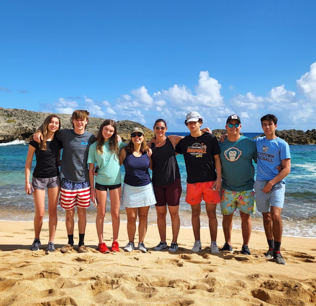 A vibrant group of college students poses on the golden sands of Mar Chiquita Beach, set against the stunning turquoise waters and bright sunny skies. Their adventure included hiking through the area’s iconic rock formations and marveling at spectacular ocean views before heading to the Rainforest Waterfalls. This memorable experience is part of Bucketlist Tours’ Ocean Edge to Jungle’s Heart private excursion, available from San Juan, Dorado, and Rio Grande.