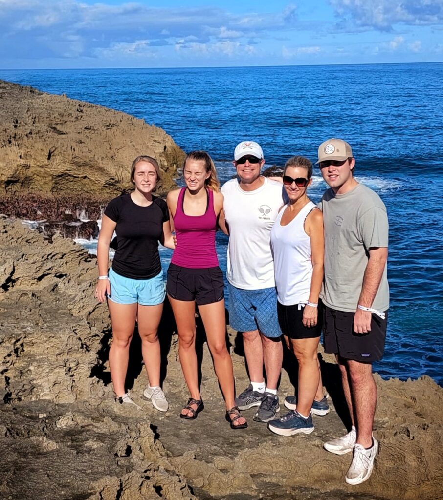 A family of five, including teenagers, enjoying a sunny day at Mar Chiquita. They are exploring the unique rock formations, hiking the scenic trail, and admiring the incredible ocean views before heading to the Rainforest Waterfalls. This memorable moment is part of Bucketlist Tours’ Ocean Edge to Jungle’s Heart private experience, tailored for families and accessible from San Juan, Dorado, and Rio Grande.