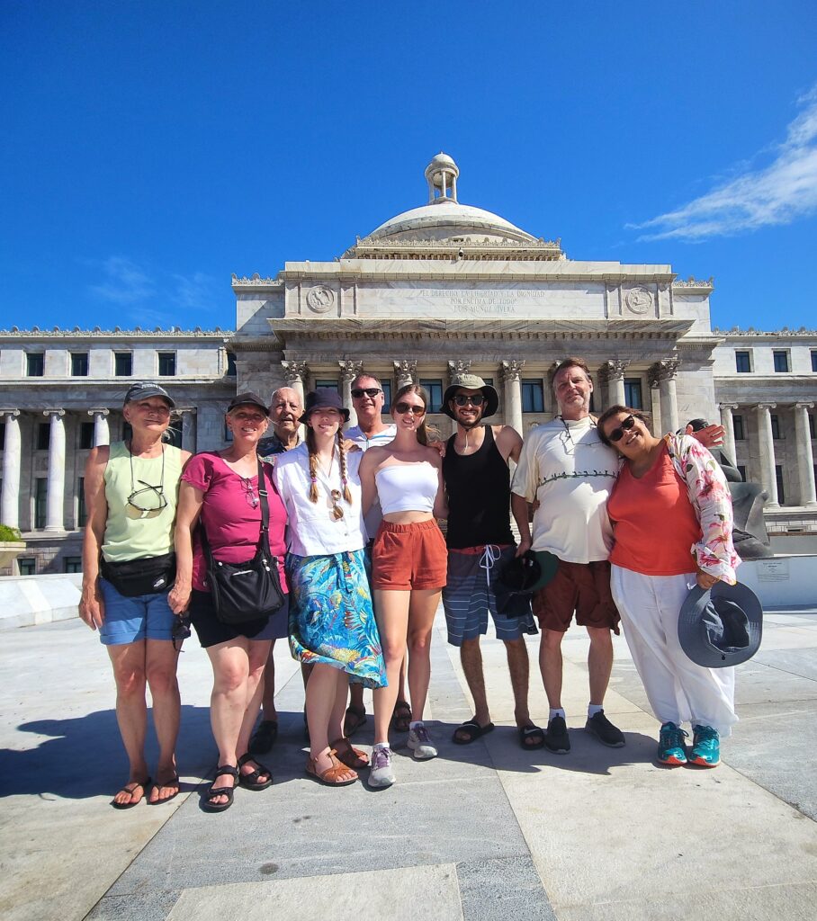 A cheerful multigenerational family poses in front of the majestic Capitol Building in San Juan, Puerto Rico. The clear blue skies and iconic architecture set the stage for a rich cultural and historical experience, highlighting the stories and heritage explored during Bucketlist Tours’ Colonial Spaniard Splendor and African Spirit Private Old San Juan Tour