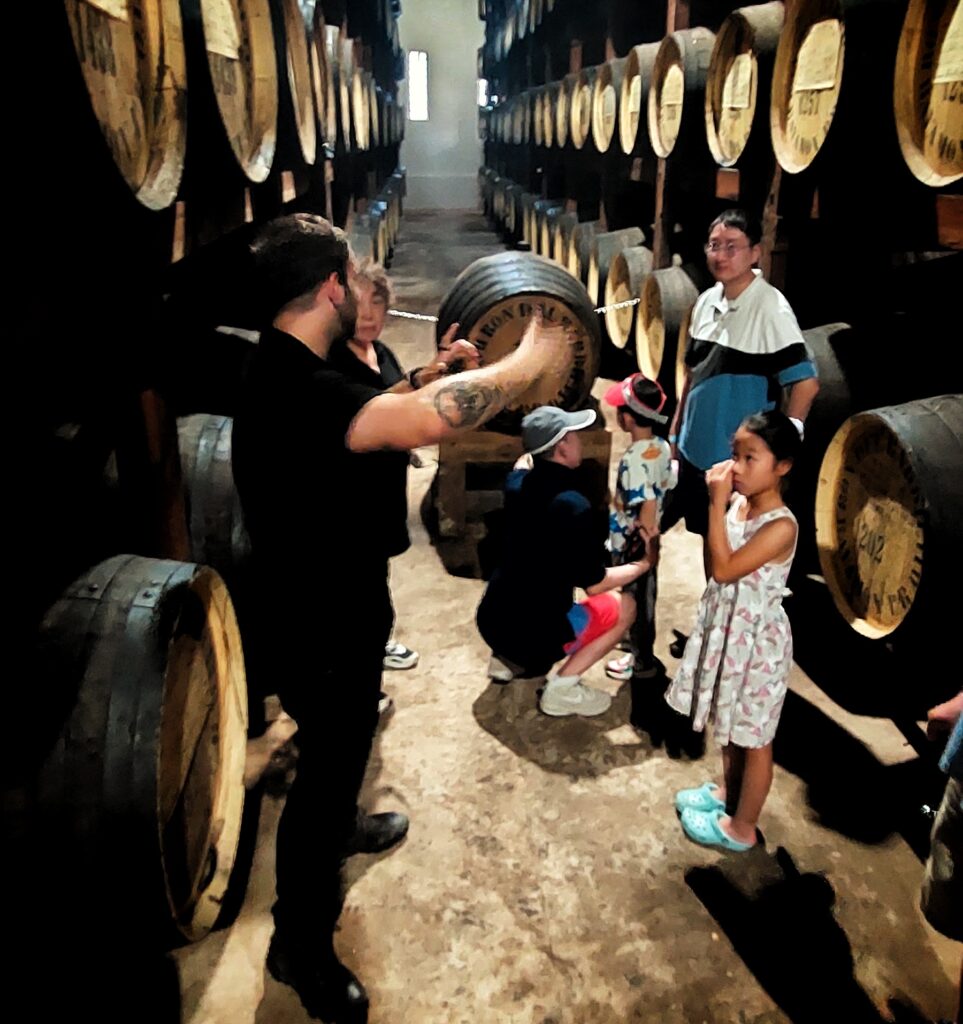 A family with young children, staying at the iconic El Convento Hotel in Old San Juan, is captured by their guide and ambassador inside the legendary *aging room* at *Barrilito Rum Distillery*. Standing beside *'La Doña,* *Puerto Rico’s oldest rum barrel* aging since 1952, the family listens intently to the distillery's fascinating history and the intricate process of creating the *world’s finest rum*. This unforgettable moment is part of their Timeless Echoes and Legendary Spirits Old San Juan and *Barrilito Distillery Private Tour*, which combines a comprehensive historic *Old San Juan tour* with an exclusive *rum distillery experience*. Covering the entire San Juan Islet, the tour includes visits to over 90 landmarks such as the *Capitol Building*, the *Walkway of the Presidents* honoring U.S. presidents who have visited the island, the North Wall, and the vibrant streets of the old city. Specially designed with safety and comfort in mind, this curated experience caters to couples, families with children, seniors, individuals with *mobility constraints*, and *cruise ship passengers* seeking an enriching and immersive journey.