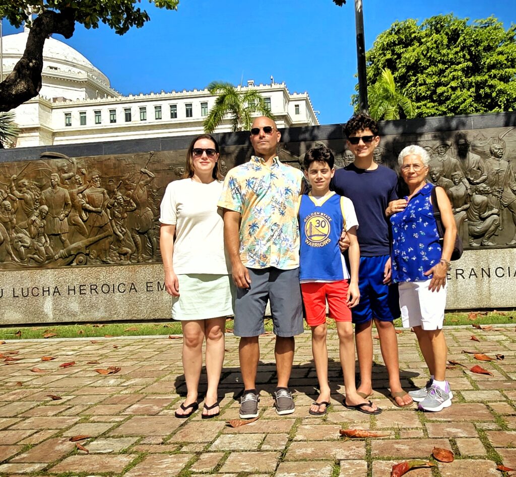 A family, including seniors, traveling to *Puerto Rico* and staying at the Condado Vanderbilt, is captured by their guide and ambassador at the *Altar de la Patria*. They stand proudly by the monument honoring *Puerto Rican women*, symbolizing resilience and contributions to the island's history. The family learns about Puerto Rico's rich colonial heritage, its transition to becoming a U.S. Commonwealth, and its pivotal role in *American history*. This meaningful moment is part of their Timeless Echoes and Legendary Spirits *Old San Juan* and *Barrilito Distillery Private Tour*, a unique blend of a *historical Old San Juan tour* and an exclusive *rum distillery experience*. The tour spans the entire San Juan Islet, featuring over 90 landmarks, including the *Capitol Building*, the *Walkway of the Presidents* honoring U.S. presidents who have visited Puerto Rico, the North Wall, and the iconic main streets of the old city. Specially curated for safety and comfort, this experience is perfect for couples, families with children, seniors, individuals with *mobility constraints*, and *cruise ship passengers* seeking an immersive exploration of Old San Juan’s history and distillery heritage.