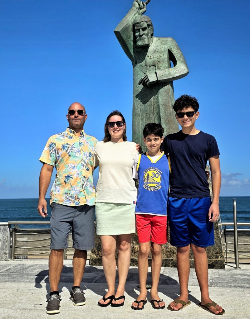 A cheerful family from Austin, staying at Condado Vanderbilt, stands proudly before the *John the Baptist* statue, the namesake of San Juan, with the stunning backdrop of the Atlantic Ocean and Puerto Rico's *state capitol building*. Guided by their dedicated ambassador, the family dives into the rich heritage and captivating history of the island on this sunny day while enjoying Bucketlist Tours' Ageless Elegance, Heritage & Spirits. This experience combine a * Capitol Building Grounds Tour*, a *historic Old San Juan tour*, a *distillery tour*, an *African Heritage tour* and a exclusive access to historic hotels; and was part of their Discover Puerto Rico 3 Day package is the only of its kind, offering an exclusive and unique package delivering the top 10 items of any Puerto Rico Vacation Bucketlist offered offered from San Juan, Dorado, Rio Grande, Isabela and Ponce.