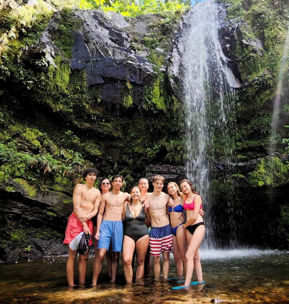 A lively group of college students from Cambridge, staying at the luxurious Fairmont El San Juan, takes a refreshing dip at the stunning *Las Delicias Waterfall* in *Toro Negro* Rainforest. Guided by Bucketlist Tours, this snapshot captures their adventurous spirit and appreciation for Puerto Rico's natural beauty as they explore the lush tropical scenery during their Tropical Rainforest Magic & Wonders. This experience combine a *roadtrip* with magnificent panoramic views, a *rainforest tour*, a visit to a pond with ancient *Taino petroglyphs* and *Puerto Rico's finest* *waterfalls*; and was part of their Discover Puerto Rico 3 Day package. The only in its kind, offering an exclusive and unique package delivering the top 10 items of any Puerto Rico Vacation Bucketlist offered offered from San Juan, Dorado, Rio Grande, Isabela and Ponce.