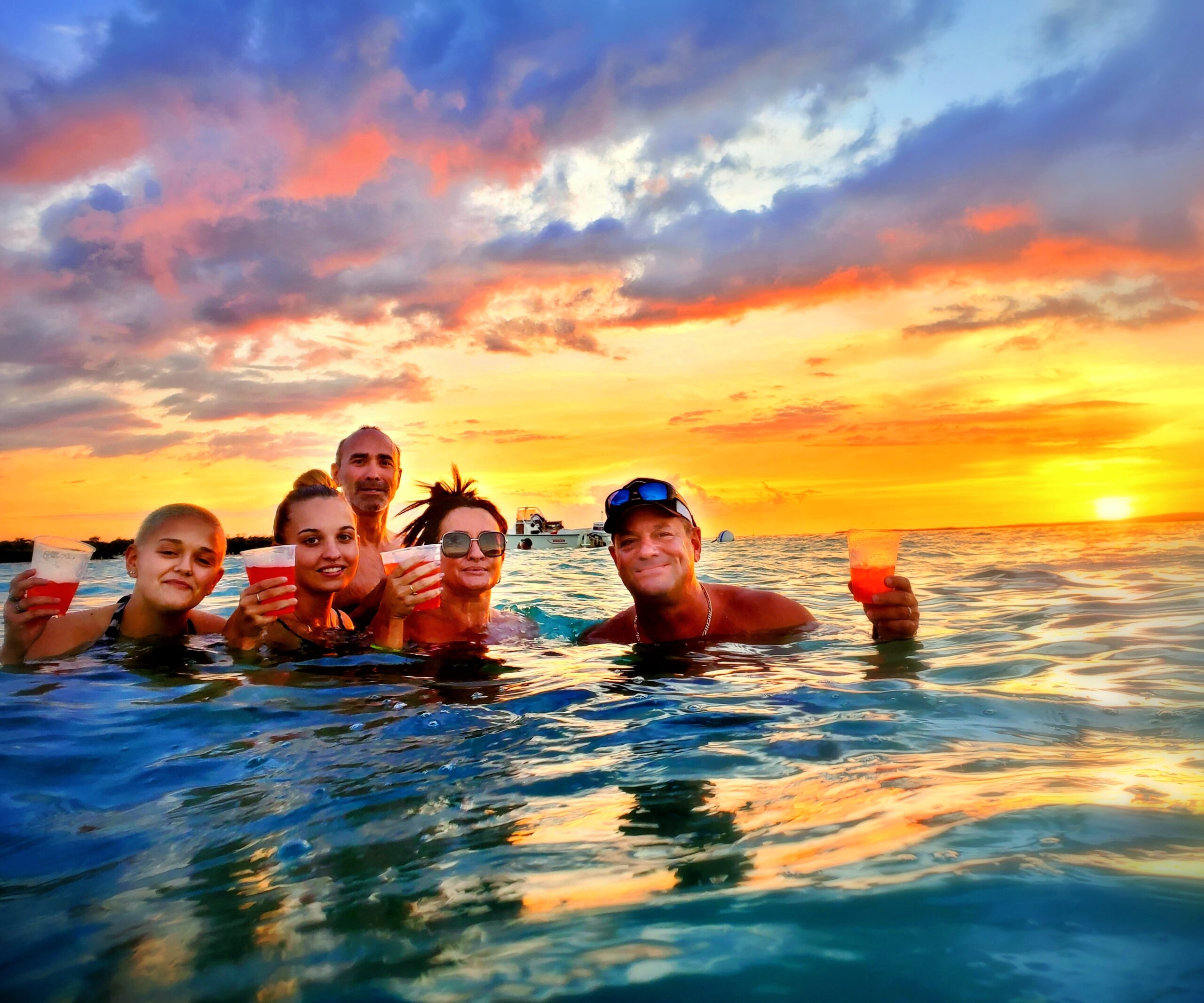 A lively group of friends, staying at El Convento Hotel in Old San Juan, bask in the vibrant hues of a magnificent *Caribbean sunset* while enjoying the warm, crystal-clear waters of *La Parguera’s Cays*. Captured thier guide and ambassador in a moment that highlights perfect blend of relaxation, adventure, and camaraderie while they enjoyed their Bucketlist Tours’ Mystic Waters under the Sun & Stars. This experience combine a ,*road trip* a *boat tour*, a *snorkeling tour*, a ,*bioluminicent bay tour*, and was part of their Discover Puerto Rico 3 Day package. The only of its kind, offering an exclusive and unique package delivering the top 10 items of any Puerto Rico Vacation Bucketlist and offered offered from San Juan, Dorado, Rio Grande, Isabela and Ponce.