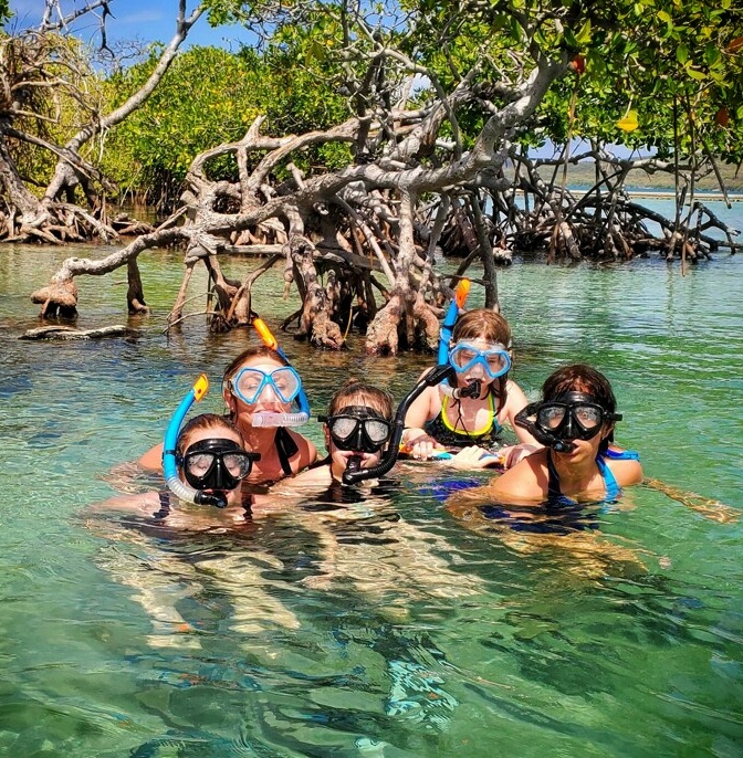 A delightful moment captured as an all-girls family, staying at El Convento Hotel in Old San Juan, enjoys snorkeling in the pristine waters of La Parguera's cays. Guided by their Bucketlist Tours ambassador, they explore the vibrant marine life and mangroves during a sunny day as part of the Mystic Waters under the Sun & Stars and Discover Puerto Rico 3-Day Package Private Experiences.