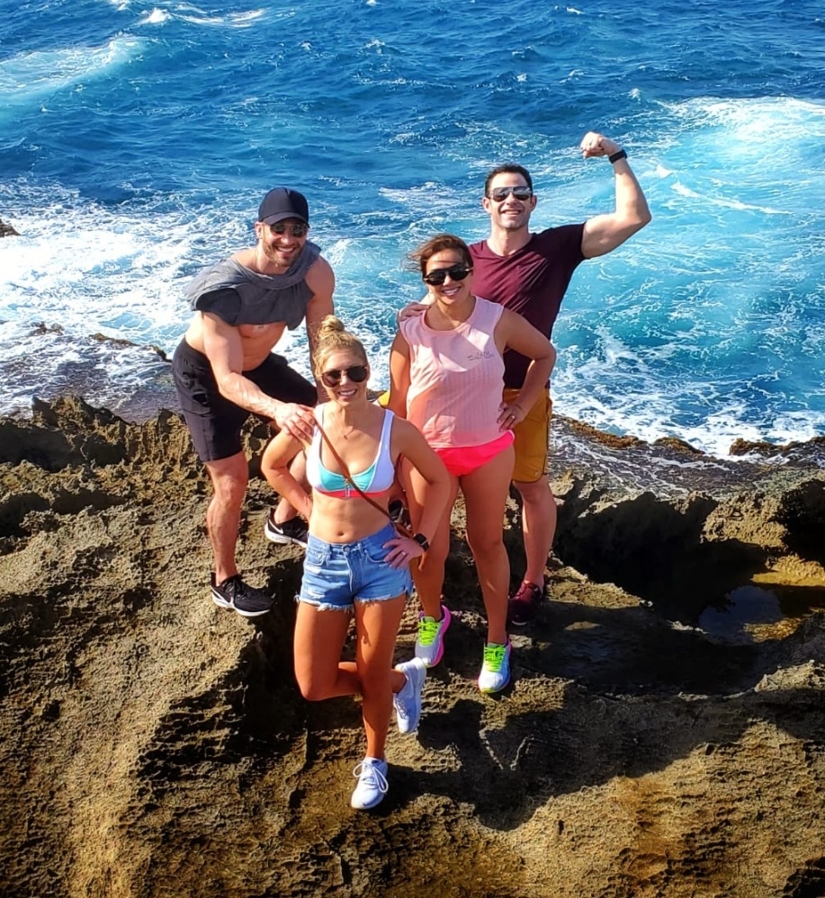 Two couples traveling to Puerto Rico, staying at Condado Vanderbilt, pose for the perfect Instagram-worthy photo captured by their guide and ambassador. The group enjoys the breathtaking ocean views and the unique rock formations during a hike at Mar Chiquita on a sunny day as part of Bucketlist Tours’ Perfect Beach Escapade: Northern Coastal Adventure Private Experience.