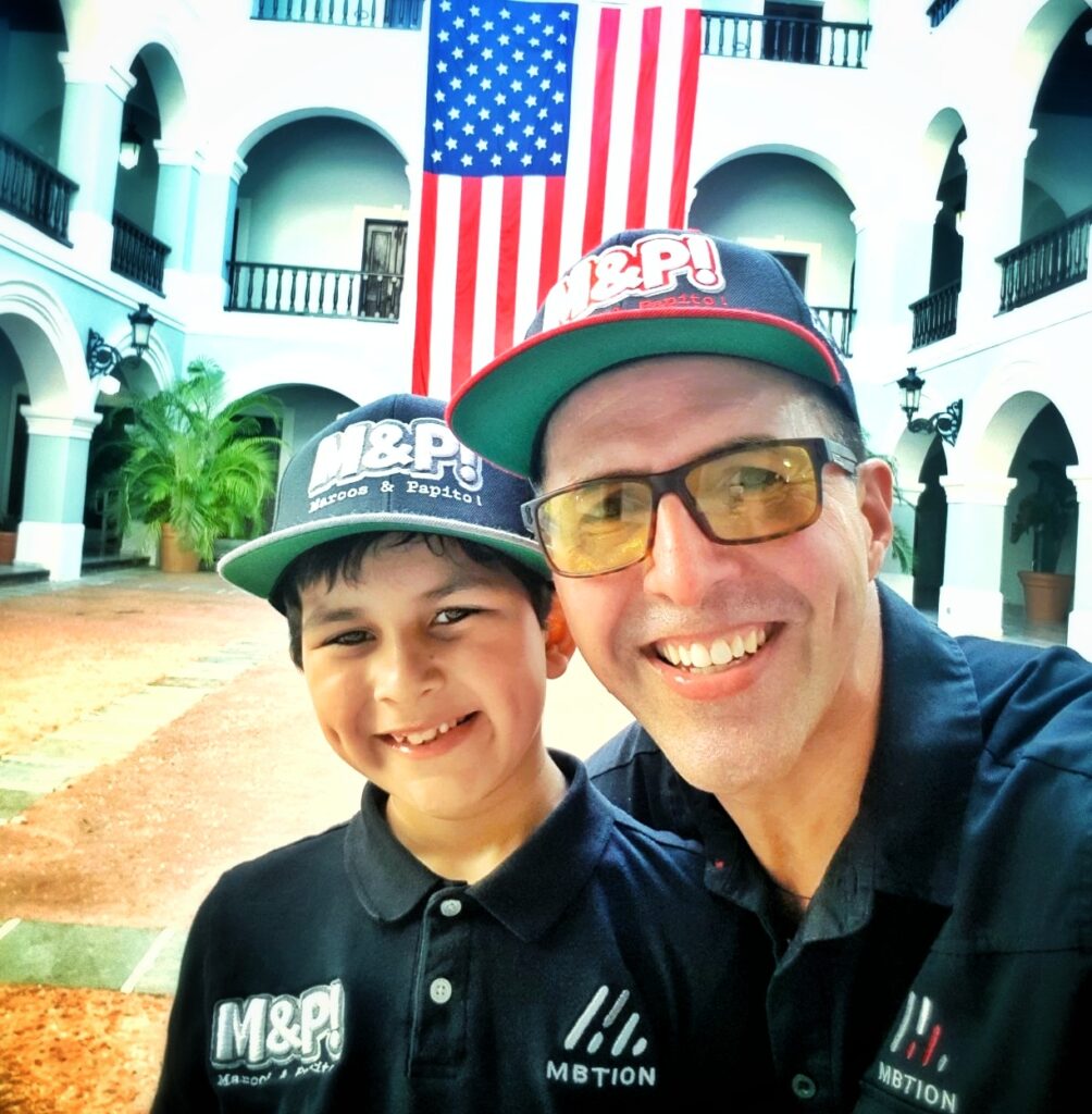 A selfie featuring Bucketlist Tours Co-Founders, Marcos & Papito!, dressed in matching uniforms with the United States flag as the backdrop. This moment captures the day they successfully conducted their first-ever Old San Juan Private Tour at the start of 2019, marking the official beginning of their journey as tour operators. This milestone represents more than the start of a small business—it symbolizes a shared passion for Puerto Rico that extends beyond its breathtaking landscapes. For Marcos and Papito, their love for the island is deeply rooted in its rich history, vibrant culture, and the warmth of its people. From uncovering hidden gems in the countryside to curating the best experiences in Old San Juan, they continue to explore and improve their offerings to this day. When guests join Bucketlist Tours, they aren’t just visiting Puerto Rico—they are experiencing it through the eyes of those who know and cherish it most.